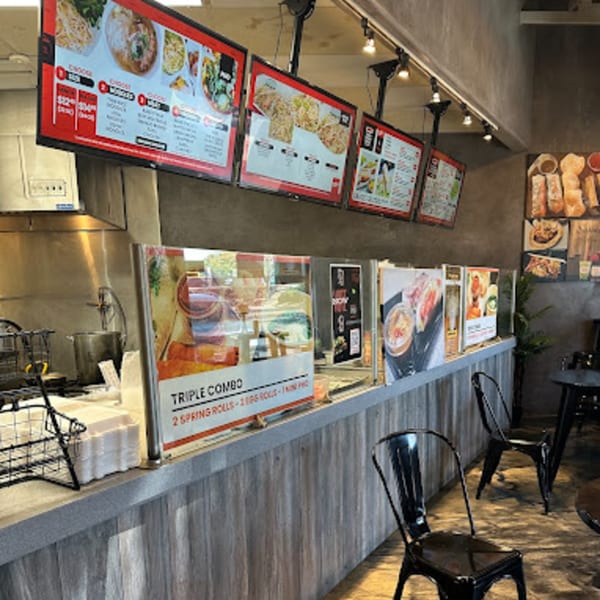 Interior of Spring Rollin, a Vietnamese restaurant, with digital menus, food counter, and seating.