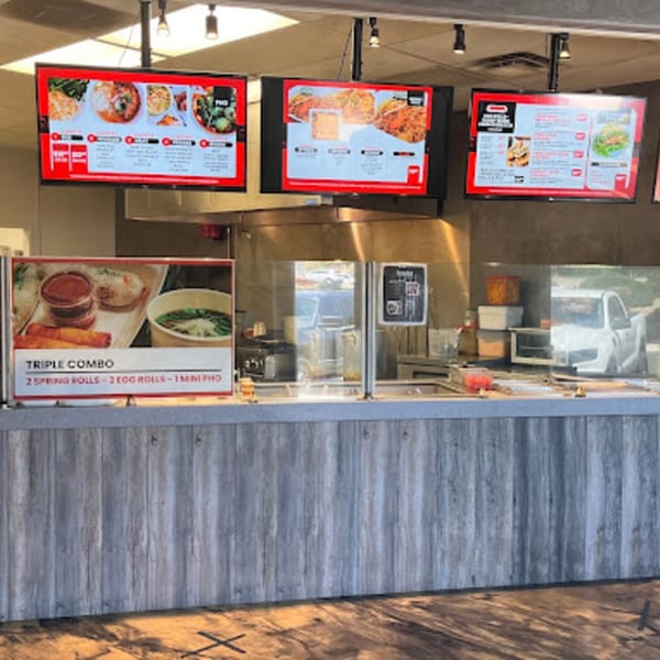 Spring Rollin's counter with digital menus displaying Vietnamese dishes and a "Triple Combo" sign.