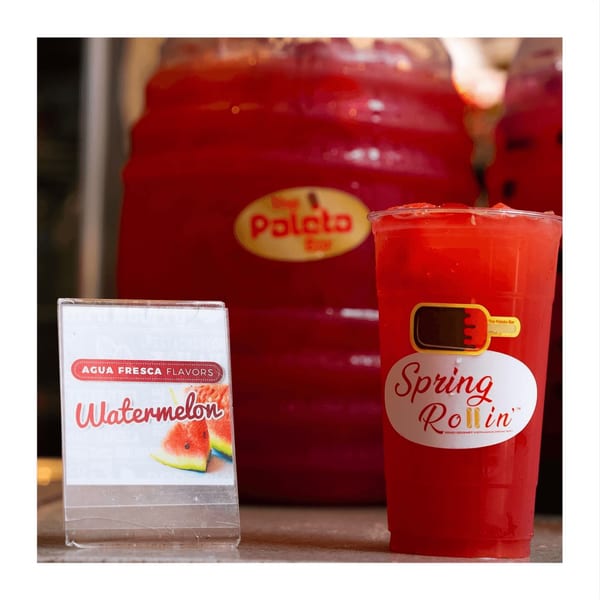 A Spring Rollin' watermelon agua fresca drink next to a watermelon flavor sign.